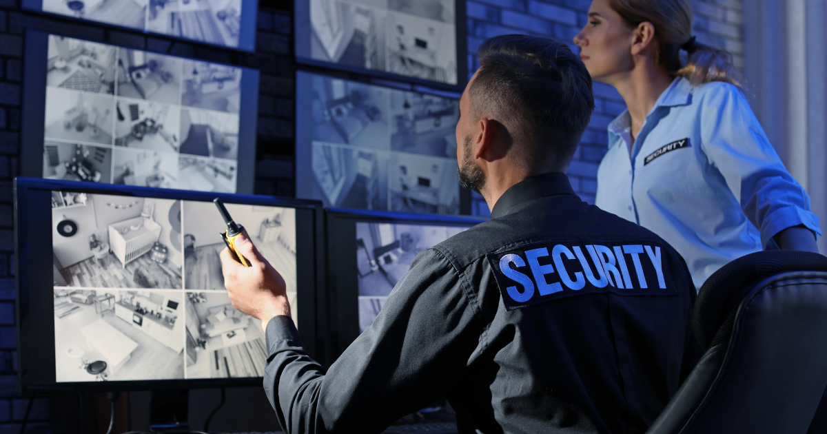 Close-up of Surveillance cameras and Security personnel looking at multiple screens